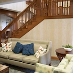 Allisonville Meadows Assisted Living offering assisted living, memory care, and respite care in Fishers, IN, sitting area with a staircase in the background