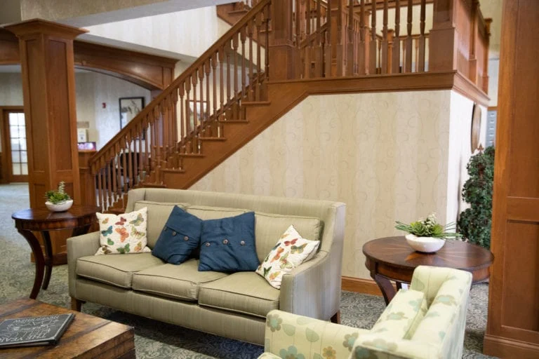 Allisonville Meadows Assisted Living offering assisted living, memory care, and respite care in Fishers, IN, sitting area with a staircase in the background