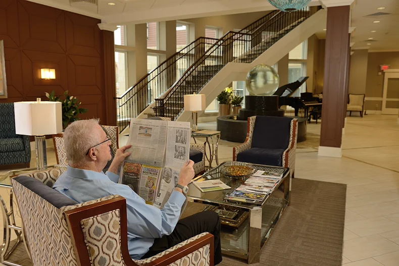 Allegro Richmond Heights senior living offering assisted living, memory care, and respite care in Richmond Heights, MO, resident experience - resident reading a newspaper
