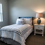 Comfortable bedroom with large window and cozy decor at Charter Senior Living of Hopkinsville in Hopkinsville, KY, designed for assisted living and memory care residents.