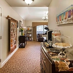 Cozy room at Charter Senior Living of Jackson in Jackson, TN, featuring baked goods, lemonade, and coffee on a side table, with a comfortable seating area including a couch, designed for assisted living and memory care residents.