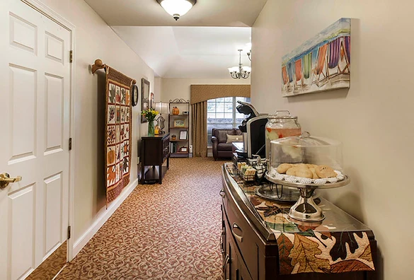 Cozy room at Charter Senior Living of Jackson in Jackson, TN, featuring baked goods, lemonade, and coffee on a side table, with a comfortable seating area including a couch, designed for assisted living and memory care residents.