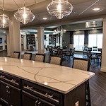 Inviting dining and lounge area at Charter Senior Living of Hopkinsville in Hopkinsville, KY, with countertop seating, tables and chairs for gathering, and a cozy sitting area—ideal for assisted living and memory care residents.