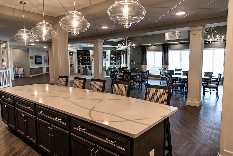 Inviting dining and lounge area at Charter Senior Living of Hopkinsville in Hopkinsville, KY, with countertop seating, tables and chairs for gathering, and a cozy sitting area—ideal for assisted living and memory care residents.