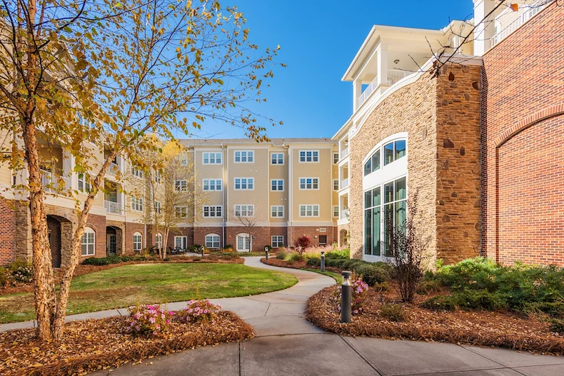 Brightmore of South Charlotte senior living community offering independent living, assisted living, and memory care in Charlotte, NC, outdoor space with a walking path