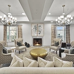 Alto Johns Creek, senior living community offering assisted living, memory care, and respite care in Duluth, GA, community living room with comfortable seating by a fireplace