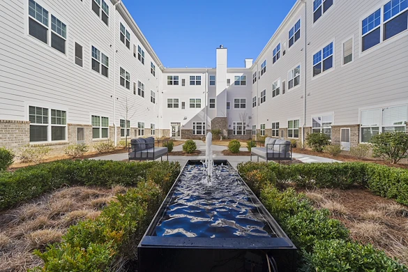 Alto Johns Creek, senior living community offering assisted living, memory care, and respite care in Duluth, GA, outdoor area with seating and a water feature