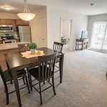Willoughby Hills Senior Apartments community offering active adult living and independent living in Willoughby Hills, OH, apartment featuring a tall dining table, kitchen, and living area