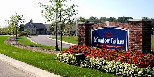 Meadow Lakes Senior Assisted Living in Mooresville, IN front exterior entrance driveway with welcome sign that says "Meadow Lakes 'An American Senior Community'"
