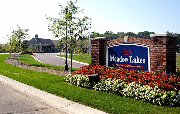 Meadow Lakes Senior Assisted Living in Mooresville, IN front exterior entrance driveway with welcome sign that says "Meadow Lakes 'An American Senior Community'"