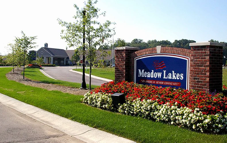 Meadow Lakes Senior Assisted Living in Mooresville, IN front exterior entrance driveway with welcome sign that says "Meadow Lakes 'An American Senior Community'"