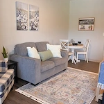 Cozy assisted living apartment at Charter Senior Living of Hopkinsville in Hopkinsville, KY, featuring a comfortable couch and a corner table for dining or relaxation.