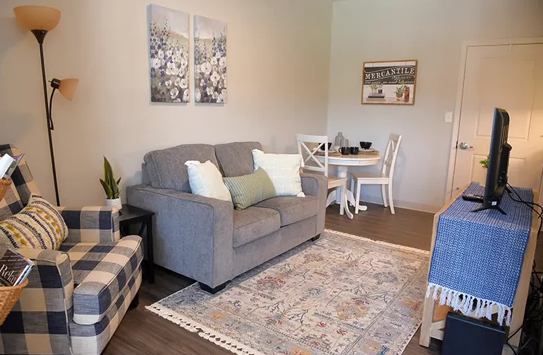 Cozy assisted living apartment at Charter Senior Living of Hopkinsville in Hopkinsville, KY, featuring a comfortable couch and a corner table for dining or relaxation.