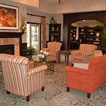 Aster Place senior living community offering independent living, assisted living, memory care, and respite care in Lafayette, IN, community living room with seating by a fireplace