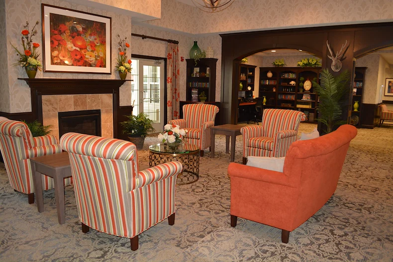 Aster Place senior living community offering independent living, assisted living, memory care, and respite care in Lafayette, IN, community living room with seating by a fireplace