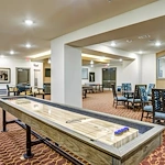 Watermere at Round Rock senior living community offering active adult living and independent living in Round Rock, TX, activities room featuring a shuffleboard table and other tables and chairs for games