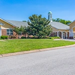 Exterior view of Charter Senior Living of Hermitage in Hermitage, TN, showcasing the welcoming brick building with landscaped grounds, offering independent living, assisted living, and memory care services for seniors.