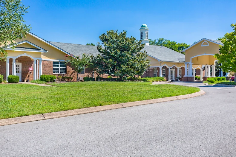 Exterior view of Charter Senior Living of Hermitage in Hermitage, TN, showcasing the welcoming brick building with landscaped grounds, offering independent living, assisted living, and memory care services for seniors.