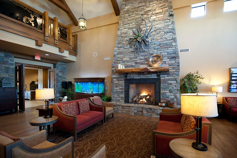 Alto Tavares, senior living community offering assisted living, memory care, and respite care in Tavares, FL, comfortable sitting area by a fireplace