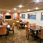 Active adult living and independent living at Watercrest at Shadow Creek Ranch in Pearland, TX, common area with tables for activities and comfortable seating by a TV