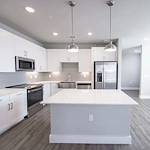 Watermere at Flower Mound senior living community offering active adult living and independent living in Flower Mound, TX, apartment kitchen with white cabinets, white countertops, and stainless steel appliances