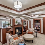 Wilshire Estates Gracious Retirement Living, independent living in Silver Spring, MD, library with seating by a fireplace