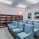 Independent living at Brightmore of Wilmington in Wilmington, NC, library and media room featuring comfortable blue chairs