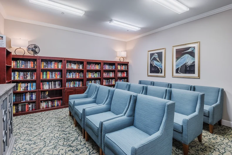 Independent living at Brightmore of Wilmington in Wilmington, NC, library and media room featuring comfortable blue chairs