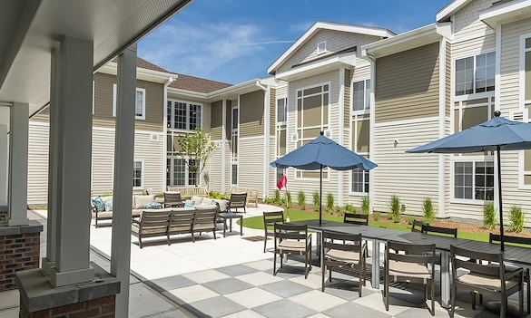 Alto Evergreen Walk, senior living community offering assisted living, memory care, and respite care in South Windsor, CT, outdoor sitting area with tables, chairs, and other comfortable furniture