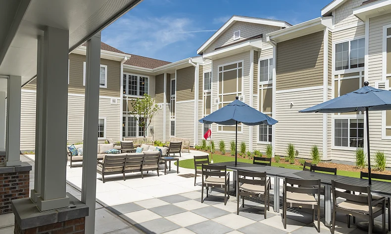 Alto Evergreen Walk, senior living community offering assisted living, memory care, and respite care in South Windsor, CT, outdoor sitting area with tables, chairs, and other comfortable furniture