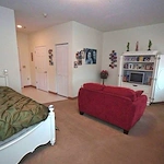 Charter Senior Living of Augusta Gardens senior living community offering assisted living and memory care in Augusta, GA, studio apartment with a bed and comfortable living area