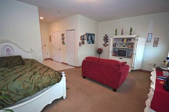 Charter Senior Living of Augusta Gardens senior living community offering assisted living and memory care in Augusta, GA, studio apartment with a bed and comfortable living area