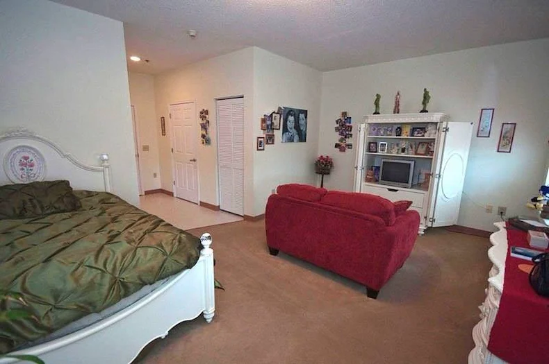 Charter Senior Living of Augusta Gardens senior living community offering assisted living and memory care in Augusta, GA, studio apartment with a bed and comfortable living area