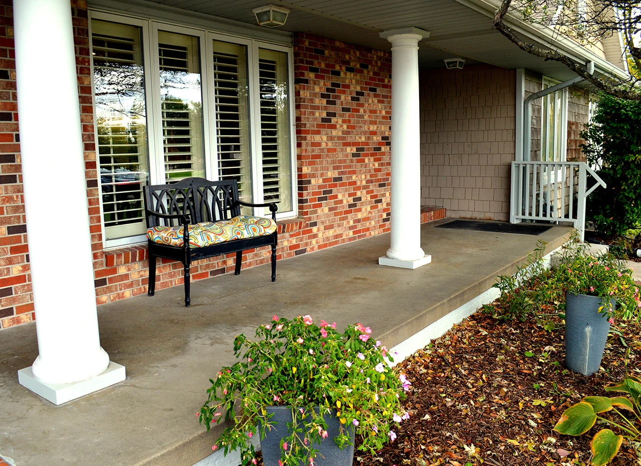 Legato Living Residential Memory Care at Legacy senior living community offering assisted living, memory care, adult day services, and respite care in Omaha, NE, front patio with a bench
