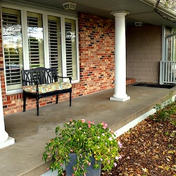 Legato Living Residential Memory Care at Legacy senior living community offering assisted living, memory care, adult day services, and respite care in Omaha, NE, front patio with a bench