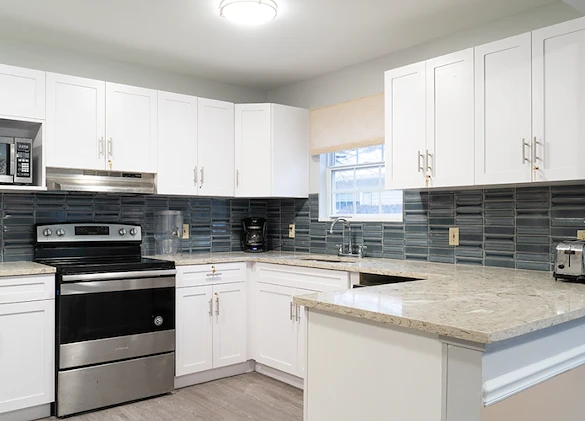 Modern kitchen at Charter Senior Living of Hazel Crest in Hazel Crest, IL, featuring white cabinets, a stove, and a beautiful, newly updated design for assisted living and memory care residents.