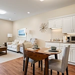 Alto Overland Park, senior living community offering assisted living and memory care in Overland Park, KS, apartment featuring a kitchenette, dining table, and comfortable living space