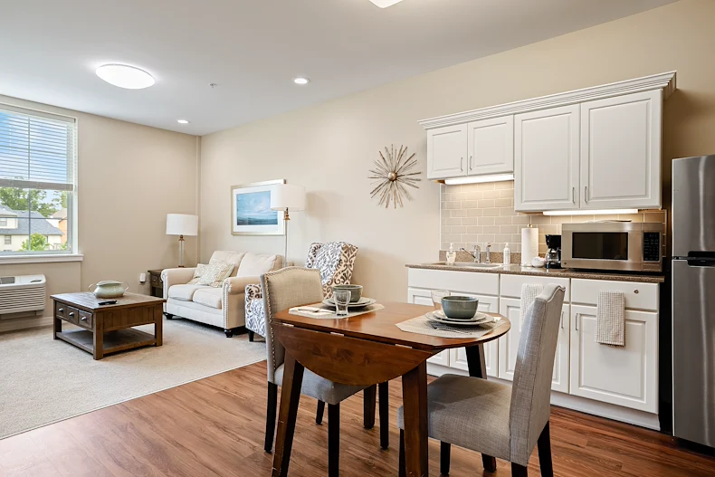 Alto Overland Park, senior living community offering assisted living and memory care in Overland Park, KS, apartment featuring a kitchenette, dining table, and comfortable living space