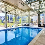 Watermere McKinney senior living community offering active adult living and independent living in McKinney, TX, pool with large garage doors that open to the outdoors