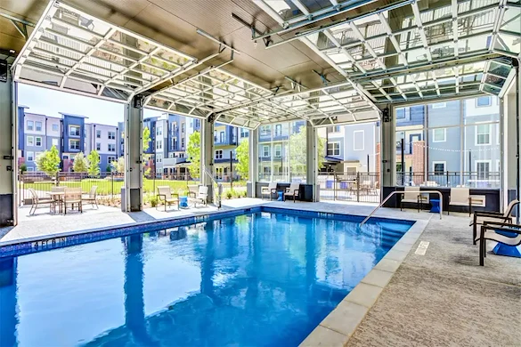 Watermere McKinney senior living community offering active adult living and independent living in McKinney, TX, pool with large garage doors that open to the outdoors