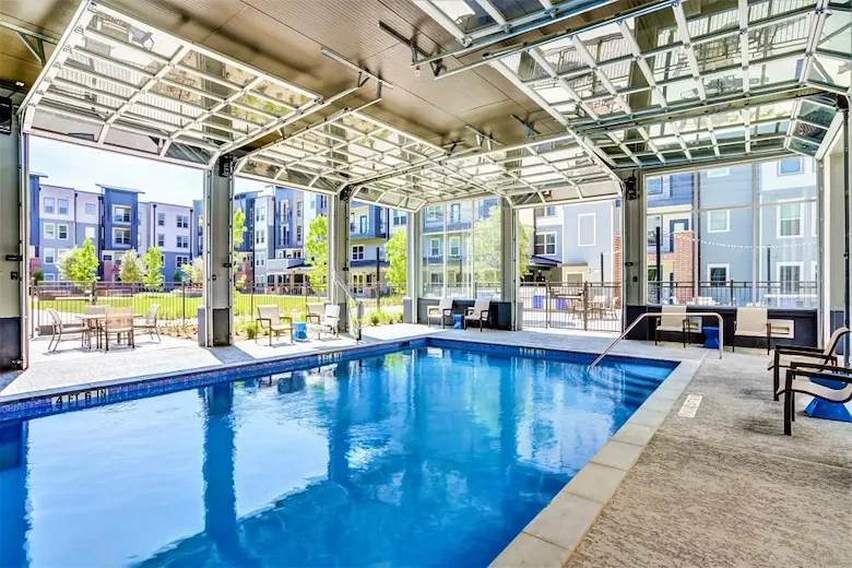 Watermere McKinney senior living community offering active adult living and independent living in McKinney, TX, pool with large garage doors that open to the outdoors