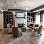 Cozy sitting area at Charter Senior Living of Hopkinsville in Hopkinsville, KY, featuring comfortable couches and chairs, a warm fireplace, and a TV—ideal for relaxation in assisted living and memory care.