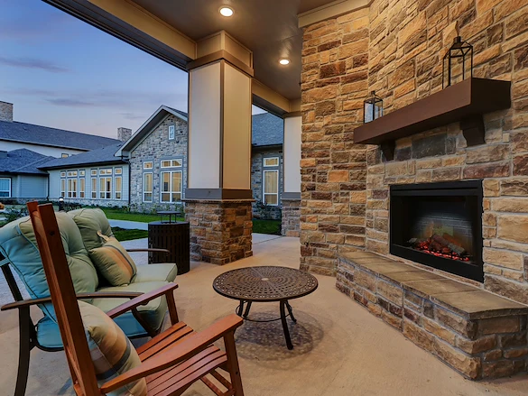 Wilshire Senior Living, independent living, assisted living, and memory care in Burleson, TX, seating by outdoor fireplace