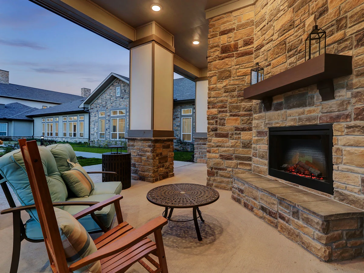 Wilshire Senior Living, independent living, assisted living, and memory care in Burleson, TX, seating by outdoor fireplace