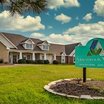 Alderbrook Village assisted living community in Arkansas City, KS, exterior view with community sign in yard and landscaped surroundings