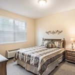 Cozy bedroom with a large window at Charter Senior Living of Hermitage in Hermitage, TN, designed for comfort in independent living, assisted living, and memory care.