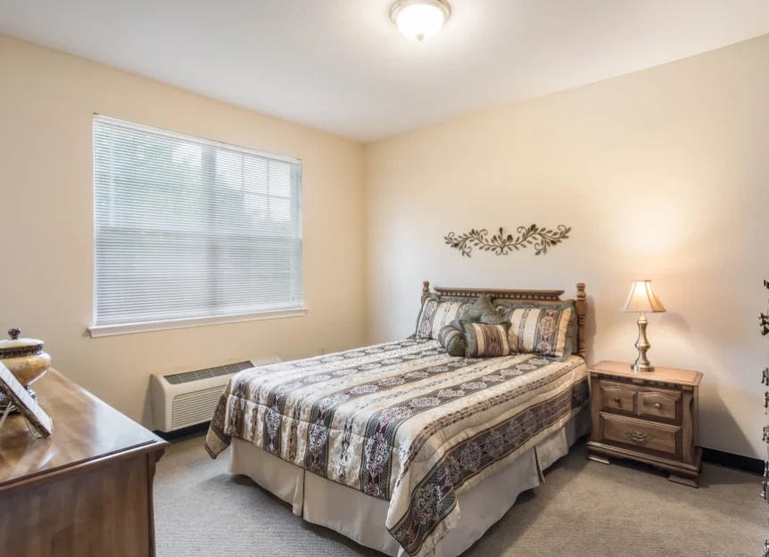 Cozy bedroom with a large window at Charter Senior Living of Hermitage in Hermitage, TN, designed for comfort in independent living, assisted living, and memory care.