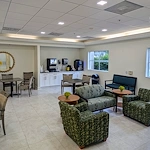 Lenox on the Lake senior living community offering assisted living and memory care in Lauderhill, FL, community dining and socializing area with tables and chairs