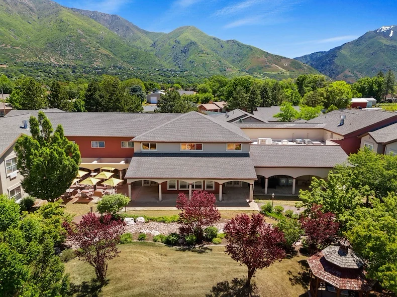 Avamere at Mountain Ridge senior living community offering assisted living, memory care, and respite care in South Ogden, UT, community exterior view with beautiful landscaping and mountains in view