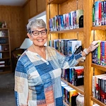 Resident enjoying the library at Fellowship Square Mesa